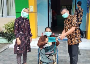Kepala Dinas Kesehatan Kabupaten Tegal dr. Hendadi Setiadji, M.Kes saat menerima masker kain produksi UMKM dari komunitas penyandang disabilitas di Halaman Kantor Dinas Kesehatan Kabupaten Tegal.