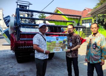 Sekretaris Daerah Kabupaten Tegal Amir Makhmud (tengah) menyerahkan bantuan mesin pemanenan padi combine harvester kepada kelompok tani di Desa Sidoarjo, Kecamatan Suradadi di halaman kantor Dinas Ketahanan Pangan dan Pertanian Kabupaten Tegal, Selasa (20/08/ 2024).