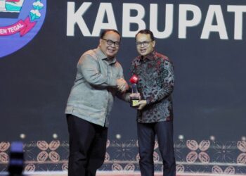 Sekretaris Daerah Kabupaten Tegal Amir Makhmud (kanan) saat menerima piala penghargaan keterbukaan informasi publik dari Direktur Trans Media Latif Harnoko (kiri) pada ajang CNN Indonesia Awards 2024 di Hotel Padma, Kota Semarang, Rabu (14/08/2024).